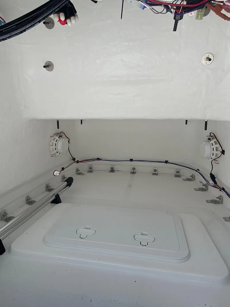 Slide: The Image of 2024 Savannah 220 IS boat interior wiring and storage compartment. - 12