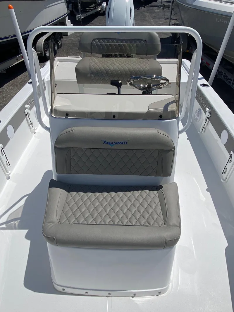 Slide: The Image of 2024 Savannah 220 IS boat interior with cushioned seating and steering console. - 13