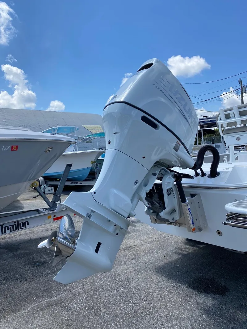 Slide: The Image of 2024 Savannah 220 IS boat with outboard motor in a marina. - 25