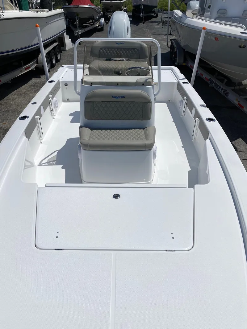 Slide: The Image of 2024 Savannah 220 IS boat with seating and console, docked among other boats. - 7
