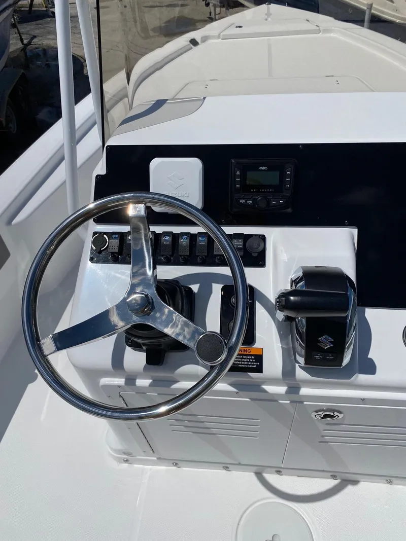 Slide: The Image of 2024 Savannah 220 IS boat dashboard with steering wheel and controls - 8