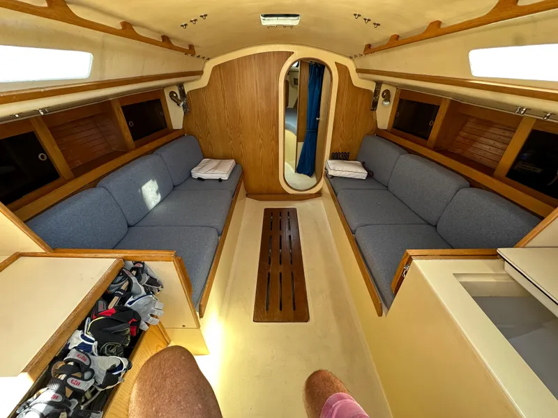 Slide: The Image of Interior of 1986 J Boats J30 sailboat with blue cushions and wooden accents. - 10