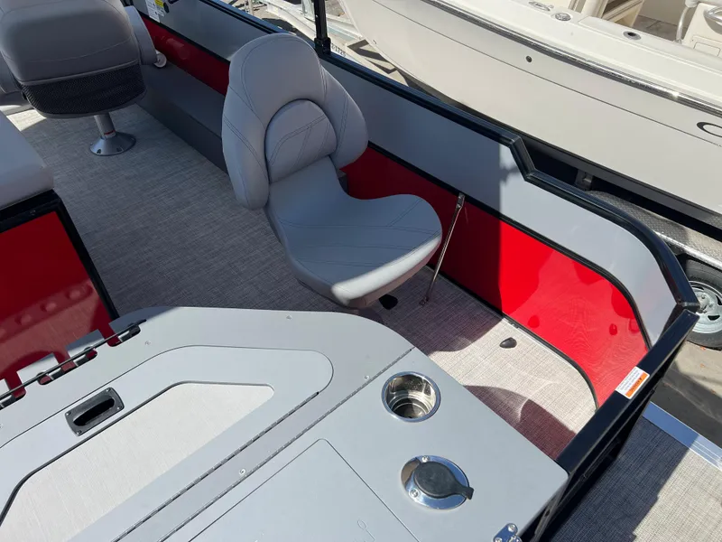Slide: The Image of 2023 South Bay 22F 200 Series boat interior with gray seating and red accents. - 16