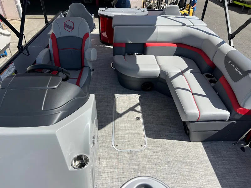 Slide: The Image of 2023 South Bay 22F 200 Series pontoon boat interior with gray and red seating. - 22