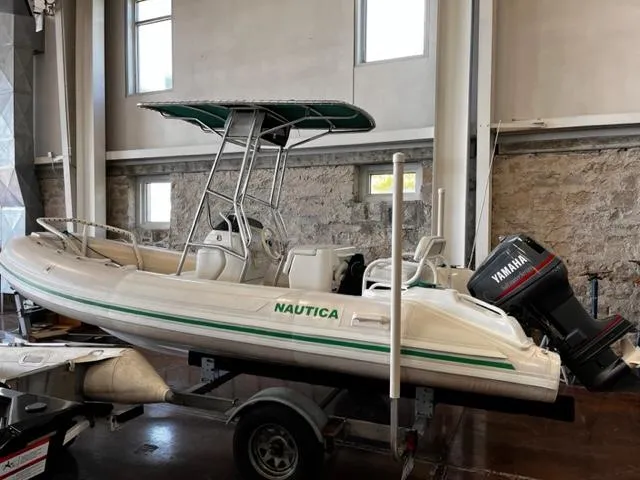 Slide: The Image of 1998 Nautica RIB 18 Widebody inflatable boat with Yamaha outboard motor in storage. - 3