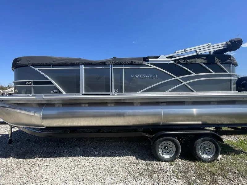 Slide: The Image of 2024 Sylvan Mirage 8522 LZ pontoon boat on a trailer under a clear blue sky. - 1