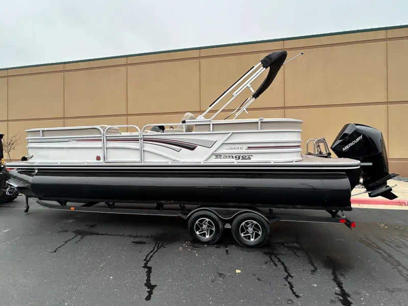 Slide: The Image of 2023 Ranger Reata 243C pontoon boat on a trailer. - 0