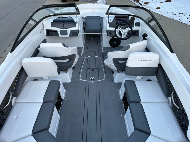 Slide: The Image of 2024 Tahoe 210 S boat interior with white and gray seating, steering wheel, and dashboard. - 12