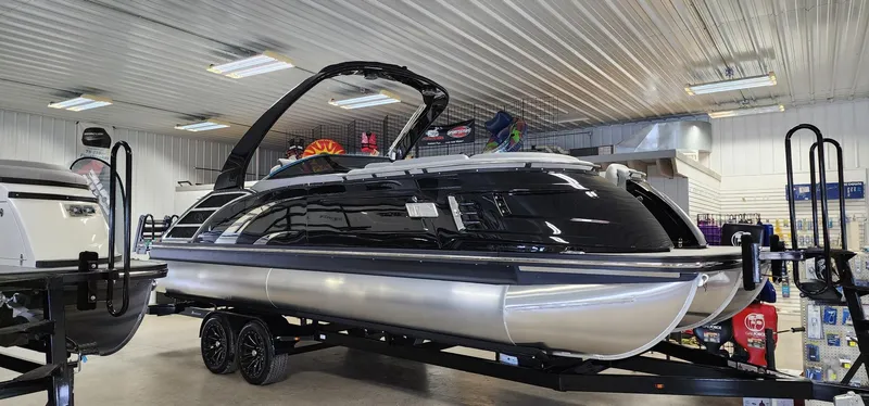 Slide: The Image of 2024 Bennington 25QXSBA pontoon boat in showroom on trailer. - 1