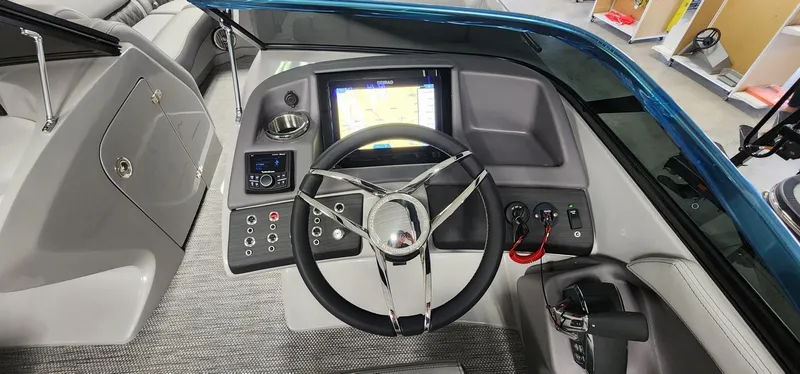 Slide: The Image of 2024 Bennington 25QXSBA boat dashboard with steering wheel and navigation display. - 10