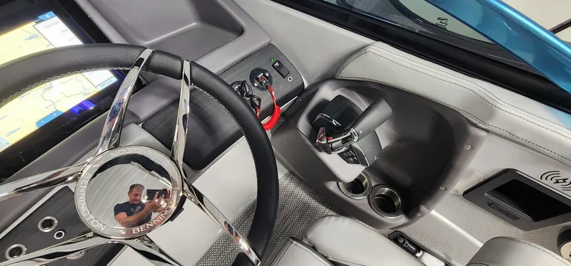 Slide: The Image of 2024 Bennington 25QXSBA boat cockpit with steering wheel and control panel. - 12