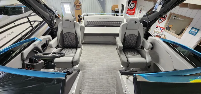 Slide: The Image of 2024 Bennington 25QXSBA boat interior with modern seating and steering console. - 4