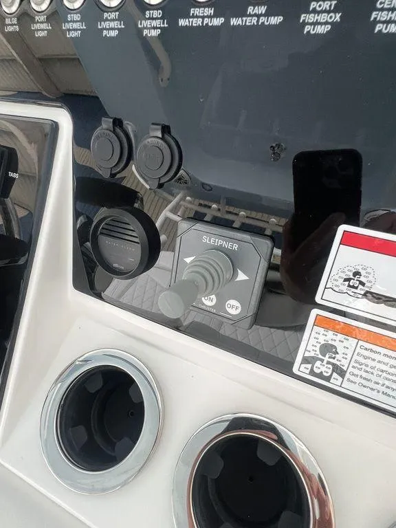 Slide: The Image of Control panel of a 2024 Fountain 34 TE boat with various switches and dials. - 14