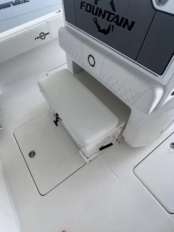 Slide: The Image of 2024 Fountain 34 TE boat interior with white seating and storage compartment. - 19