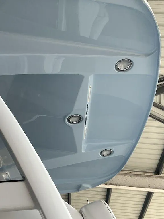 Slide: The Image of 2024 Fountain 34 TE boat hull in light blue, viewed from below in a covered area. - 25