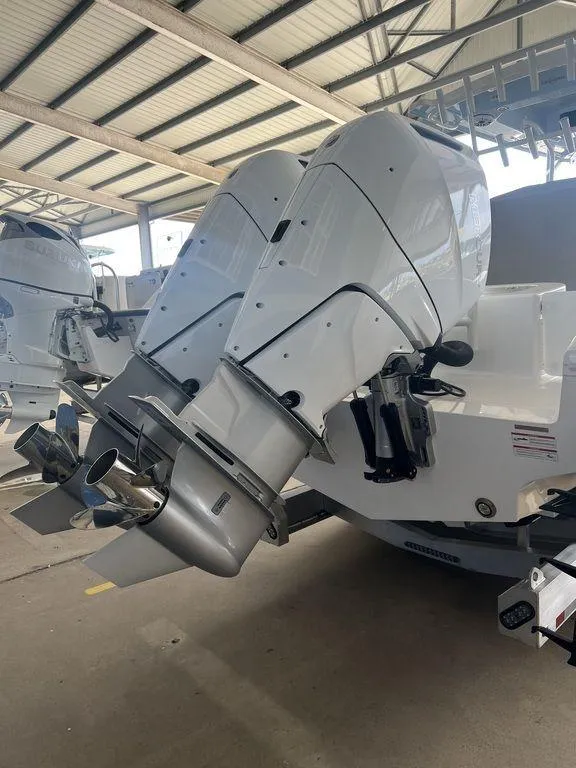 Slide: The Image of 2024 Fountain 34 TE boat with dual outboard engines in a covered marina. - 5