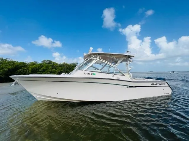 The Image of 2014 Grady-White Freedom 335 boat on calm water with blue sky background. - 0