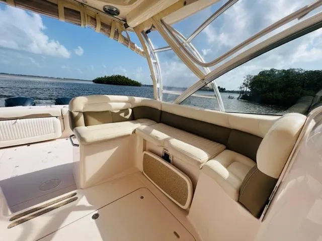 Slide: The Image of 2014 Grady-White Freedom 335 boat interior with cushioned seating, ocean view in background. - 26