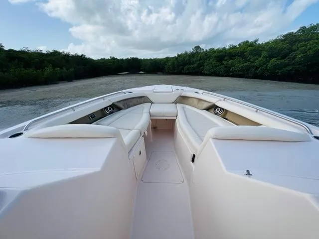 Slide: The Image of 2014 Grady-White Freedom 335 boat with spacious seating, docked near lush greenery. - 33