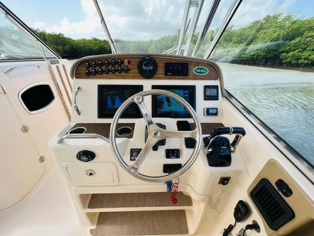 Slide: The Image of 2014 Grady-White Freedom 335 boat helm with steering wheel and navigation controls. - 39