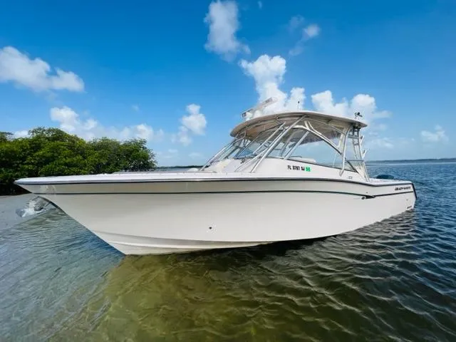 Slide: The Image of 2014 Grady-White Freedom 335 boat on calm water with blue sky background. - 4