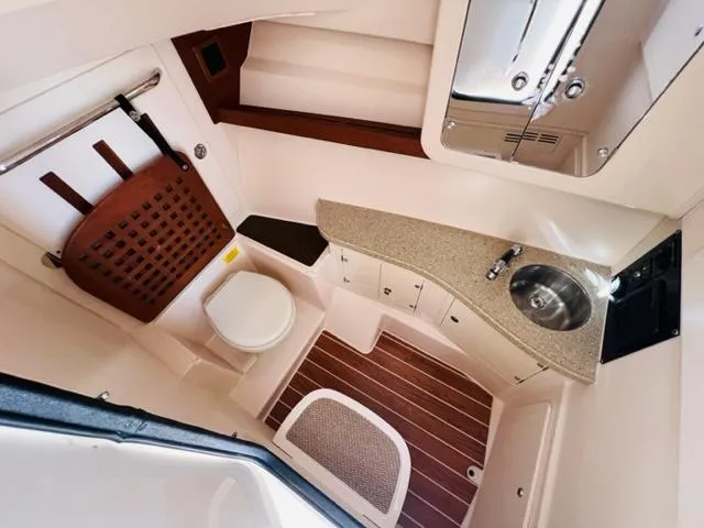 Slide: The Image of 2014 Grady-White Freedom 335 boat interior with toilet, sink, and wooden flooring. - 46