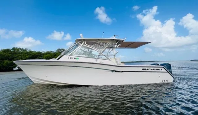 Slide: The Image of 2014 Grady-White Freedom 335 boat on calm water with blue sky background. - 7