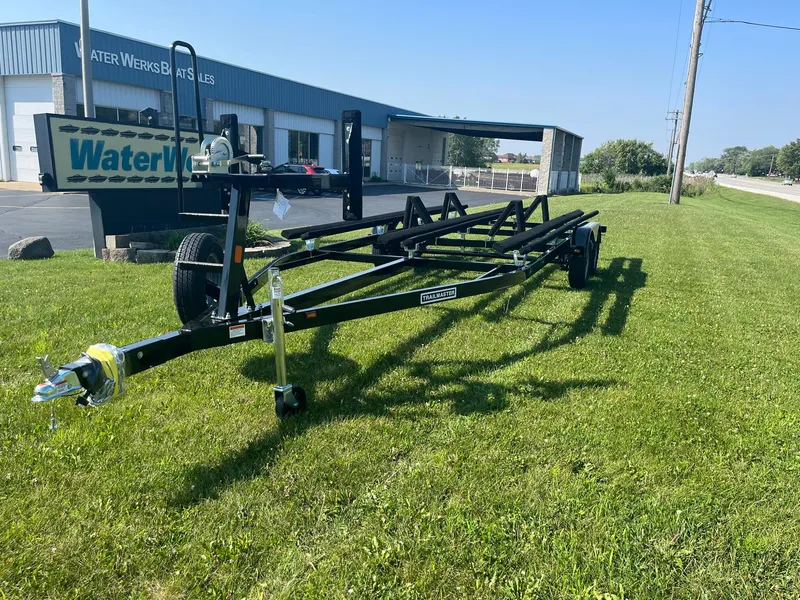 Slide: The Image of 2024 Pontoon Trailer on grass near Water Werks Boat Sales building. - 1