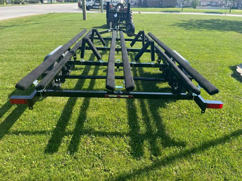 Slide: The Image of 2024 Pontoon Trailer on grass, rear view, black frame, red reflectors. - 6
