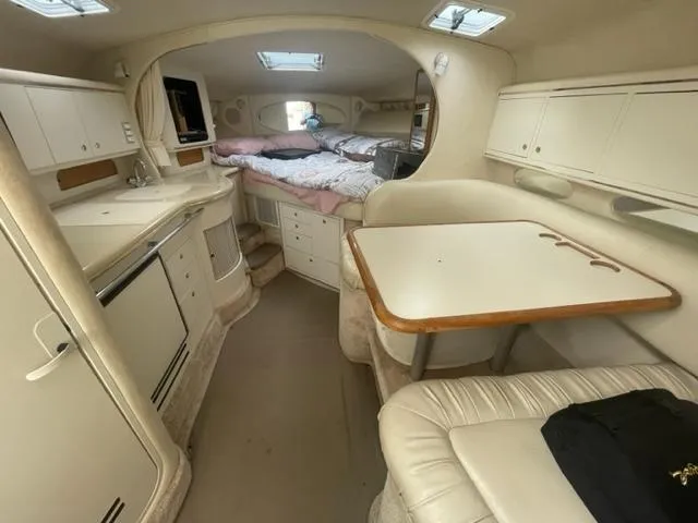 Slide: The Image of 1999 Sea Ray 310 DA cabin interior with kitchenette, dining area, and sleeping quarters. - 10