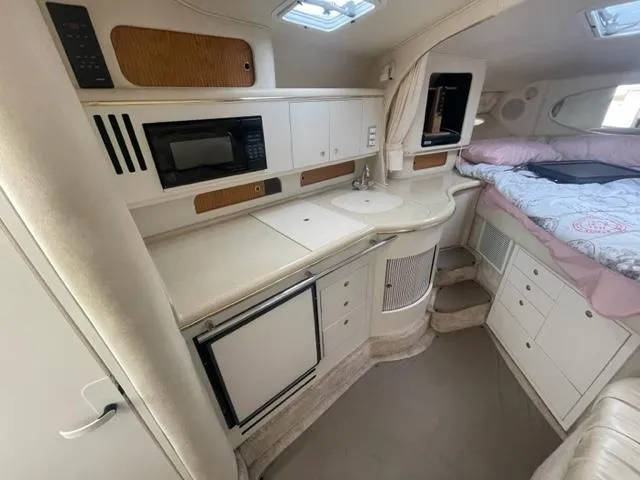 Slide: The Image of 1999 Sea Ray 310 DA cabin interior with kitchenette and sleeping area. - 12
