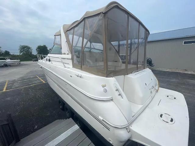 Slide: The Image of 1999 Sea Ray 310 DA boat with tan canvas enclosure, docked in a marina. - 3