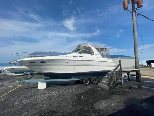 Slide: The Image of 1999 Sea Ray 310 DA boat on trailer in marina under blue sky. - 4