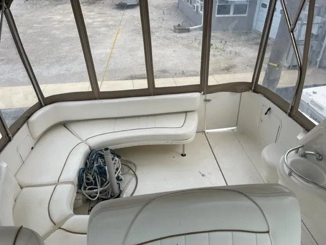 Slide: The Image of 1999 Sea Ray 310 DA boat interior with white seating and coiled ropes. - 9