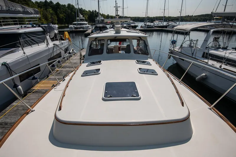 Slide: The Image of 2003 Hinckley Talaria 44 Express yacht docked at a marina, surrounded by other boats. - 14