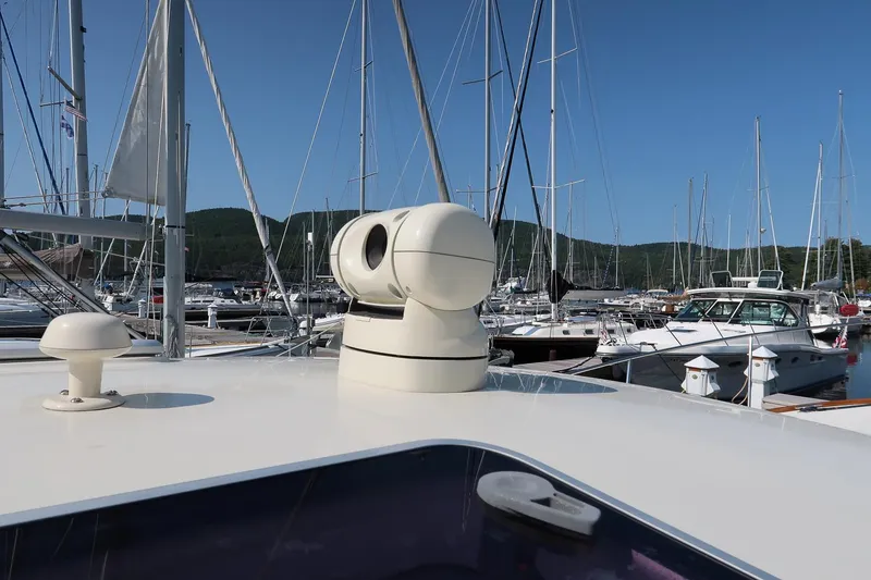 Slide: The Image of 2003 Hinckley Talaria 44 Express yacht in marina, surrounded by sailboats under clear blue sky. - 15