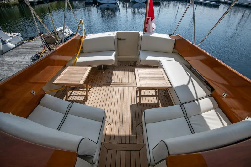 Slide: The Image of 2003 Hinckley Talaria 44 Express yacht with elegant teak deck and cushioned seating. - 17