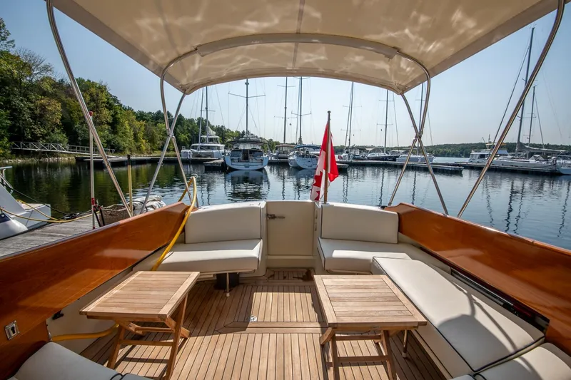 Slide: The Image of Hinckley Talaria 44 Express 2003 yacht interior with seating, tables, and marina view. - 18