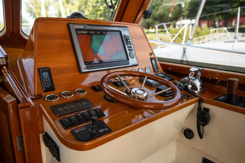 Slide: The Image of 2003 Hinckley Talaria 44 Express helm with wooden steering wheel and navigation system. - 26