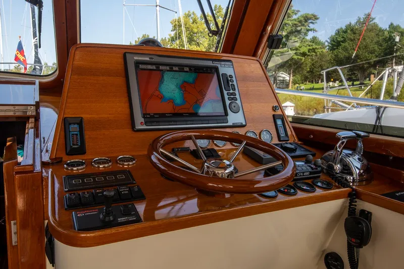 Slide: The Image of 2003 Hinckley Talaria 44 Express helm with navigation system and wooden steering wheel. - 27