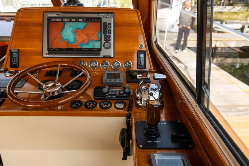 Slide: The Image of Helm of 2003 Hinckley Talaria 44 Express with navigation equipment and wooden steering wheel. - 28