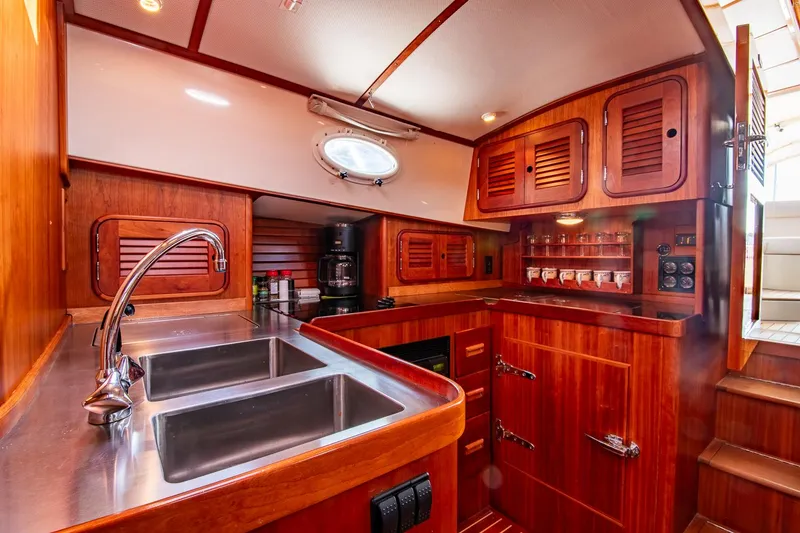 Slide: The Image of Luxurious 2003 Hinckley Talaria 44 Express yacht kitchen with wooden cabinetry and stainless steel sink. - 33