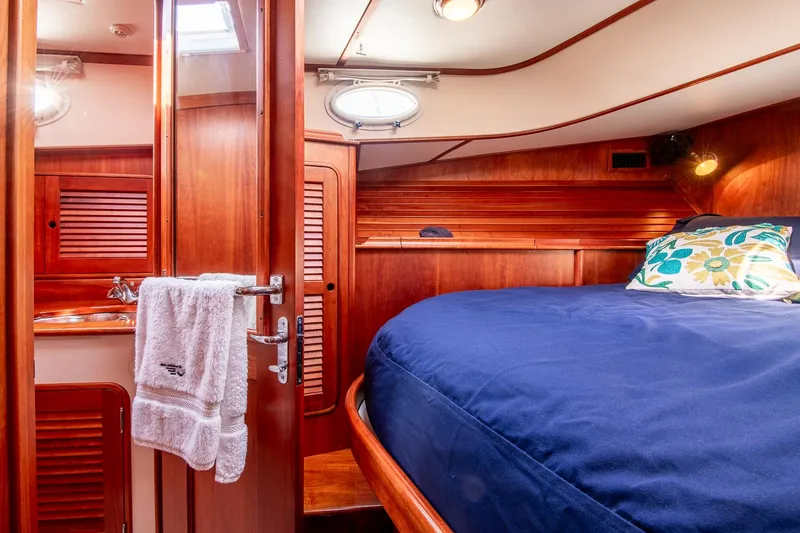 Slide: The Image of Hinckley Talaria 44 Express 2003 cabin with wooden interior and cozy bed. - 36