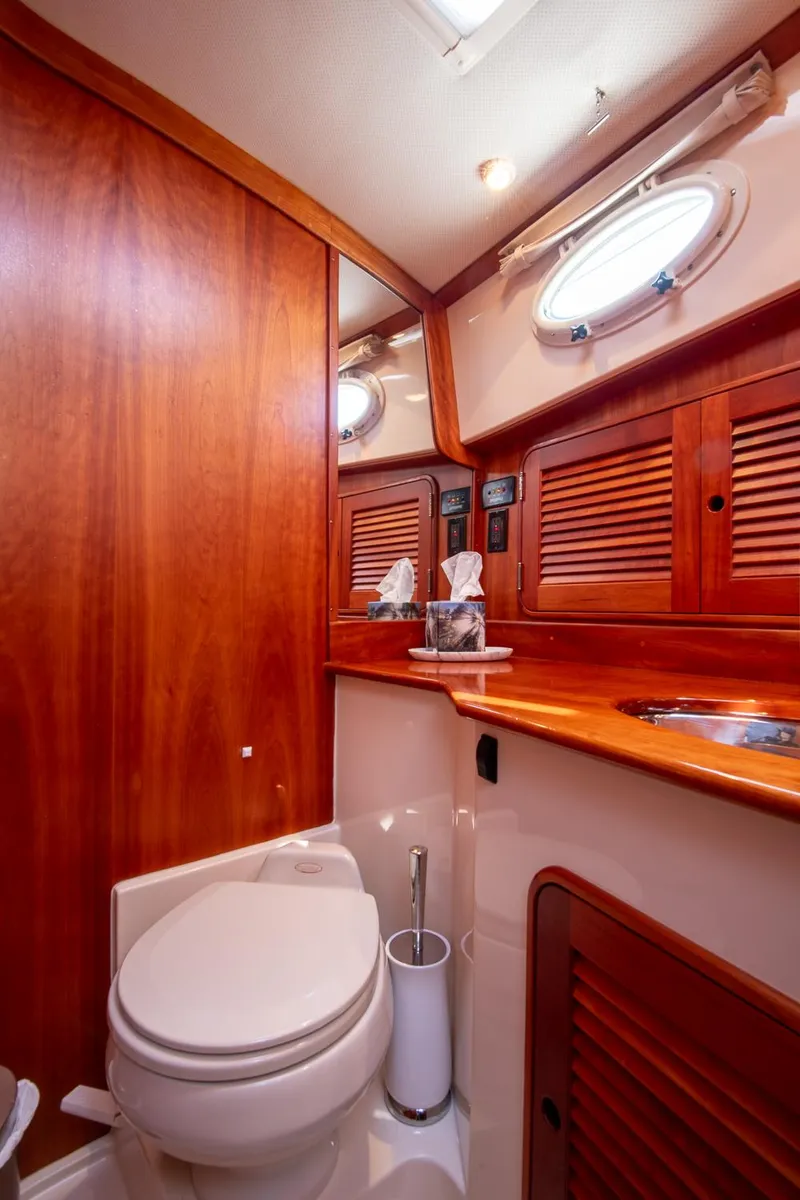 Slide: The Image of Luxurious 2003 Hinckley Talaria 44 Express yacht bathroom with wood accents and porthole window. - 39