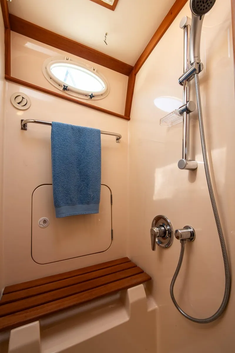 Slide: The Image of Shower area in 2003 Hinckley Talaria 44 Express yacht with wooden bench and blue towel. - 41