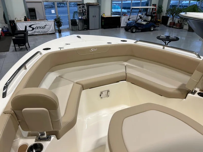 Slide: The Image of 2024 Scout 215 XSF boat interior with beige seating in showroom. - 7