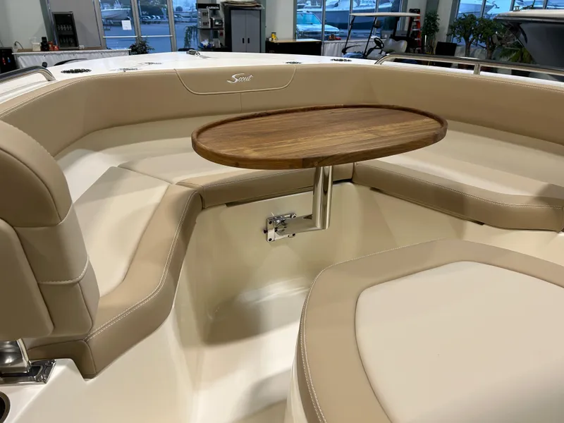 Slide: The Image of 2024 Scout 215 XSF boat interior with beige seating and wooden table. - 8