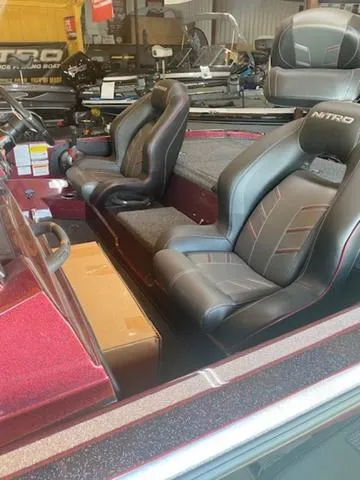 Slide: The Image of 2024 Nitro Z18 boat interior with black and red seats in showroom. - 2