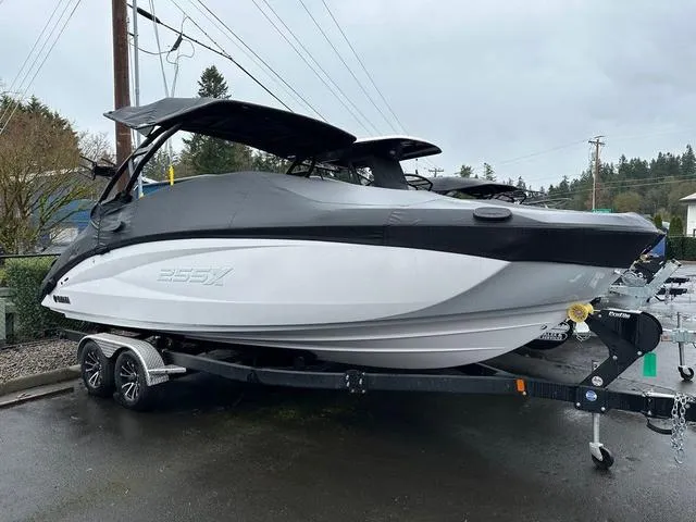 Slide: The Image of 2024 Yamaha Boats 255XE on trailer, covered, parked outdoors on a cloudy day. - 15