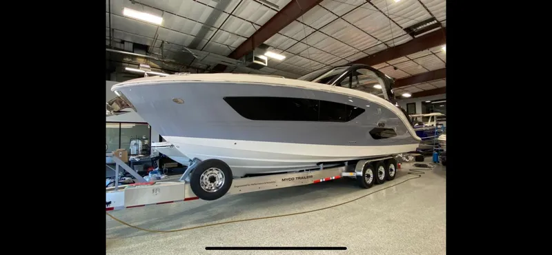 Slide: The Image of 2025 Sea Ray Sundancer 370 OB luxury boat on display at a marina. - 24